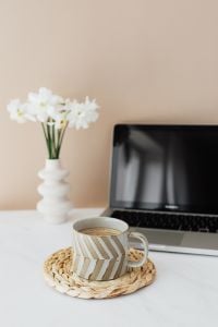 Kaboompics - Striped Ceramic Coffee Mug on Woven Coaster beside Laptop