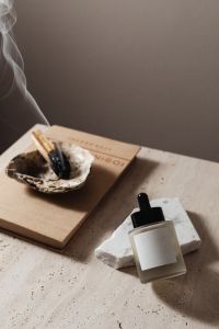 Kaboompics - Serum Bottle and Burning Incense in a Shell Dish on a Neutral Book