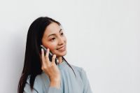 Kaboompics - Smiling Asian Woman Taking a Phone Call in Close-Up