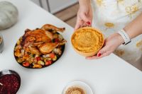 Kaboompics - Woman Holding Mashed Sweet Potatoes beside Roast Turkey