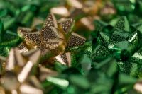 Kaboompics - Gold Metallic Gift Bows on Green Background