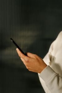 Kaboompics - Smartphone Close-Up With Hand Against Dark Background