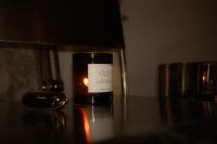 Kaboompics - Burning Amber Candle on Dark Side Table