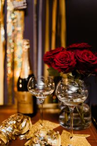 Kaboompics - Champagne Bottle, Two Glasses and Red Roses in a Vertical New Year Party Scene