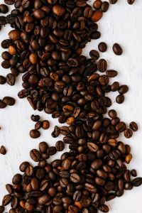 Dark Roasted Coffee Beans Framing a White Background for Cafe Design