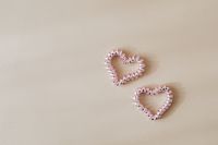 Kaboompics - Two Pink Beaded Hearts on Beige Background with Left Copy Space