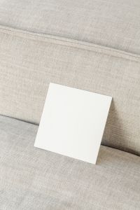 Kaboompics - Square Flyer Mockup with Negative Space on a Linen Sofa