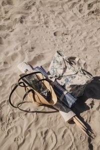 Kaboompics - Beach Bag, Hat and Folded Floral Clothing on the Sand