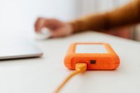 Kaboompics - Man works on a computer at his desk, mobile phone, portable hard drive