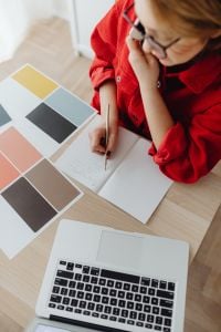 Kaboompics - Top-Down View of Woman Taking Notes with Smartphone, Laptop and Color Sample Cards