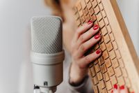 Kaboompics - Close-Up Red-Nailed Hand Tapping a Wooden Sound Prop beside Microphone