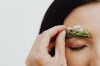 Kaboompics - Applying White Blossoms and Greenery to Eyebrow, Asian Beauty Close-Up with Copy Space