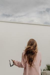 Kaboompics - Woman in Pink Sweater and Sunglasses Using Smartphone in Armchair
