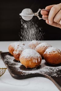 Kaboompics - Fresh Polish Doughnuts Being Dusted with Powdered Sugar