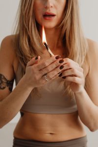 Kaboompics - Woman Lighting a Palo Santo Stick With an Open Flame