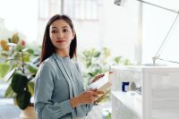 Kaboompics - Asian Woman Holding a Notebook Beside Office Shelves