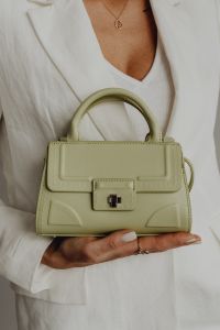 Kaboompics - Structured Pale Green Handbag Presented on Open Palm, Neutral Fashion