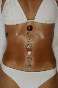 Kaboompics - Vertical Seashell Arrangement on Tanned Skin and White Bikini