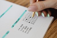Kaboompics - Hand Marking a Bullet Journal Habit Tracker