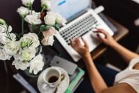 Kaboompics - Woman Working On Laptop Beside White Flowers