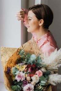 Woman Holding a Mixed Flower Bouquet Wrapped in Paper