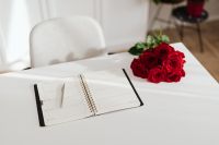 Kaboompics - White Weekly Planner and Pen Beside Red Roses, Minimal Office Desk