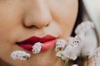Kaboompics - Red Lipstick and White Flowers Framing an Asian Woman's Mouth, Floral Beauty Close-Up