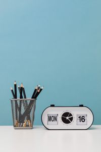 Kaboompics - Black Pencils and Retro Desk Clock on Blue Background