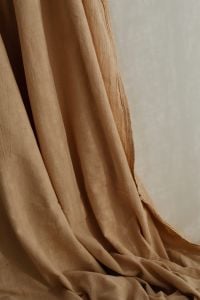 Kaboompics - Draped Beige Curtain beside Light Neutral Wall, Soft Fabric Folds