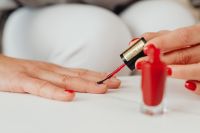 Kaboompics - Red Nail Polish Application with Bottle in the Foreground for Nail Care Tutorials