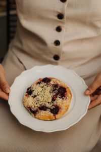 Kaboompics - Person Holding a Cherry Pastry on a Plate