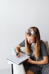 Kaboompics - Girl Writing Notes in Notebook at Home