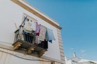 Kaboompics - Laundry Drying on a Wrought-Iron Balcony Against Blue Sky