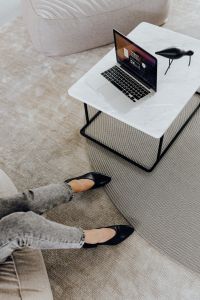 Kaboompics - Laptop and Sculptural Bird on White Coffee Table, Minimal Home Office with Gray Denim Detail
