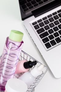 Kaboompics - Beauty Products in Shopping Basket beside Laptop Close-Up