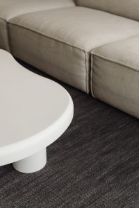 Kaboompics - Beige Sofa and White Round Coffee Table on a Dark Rug