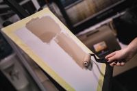 Kaboompics - Applying Warm Beige Paint to Canvas with a Roller, Close-Up of the Painting Process
