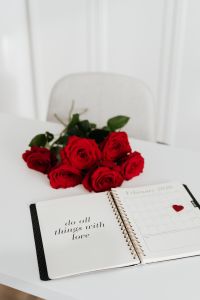 Kaboompics - Vertical Valentine's Desk Scene with Open Weekly Planner, Red Rose Bouquet and Heart