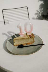 Kaboompics - Cake Slice with Pink Number Candles on an Outdoor Table