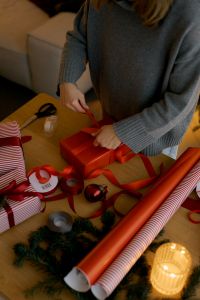 Kaboompics - Person Tying Bow on Red Christmas Gift Box