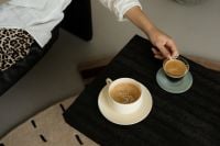 Kaboompics - Woman Reaching for Espresso During Coffee Break
