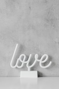 Kaboompics - White Love Sign Displayed on Gray Wall and Table