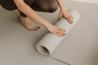 Kaboompics - Wide View of Woman Rolling a Yoga Mat on the Floor