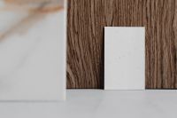 Kaboompics - Close-Up Blank Card on Wood with Soft-Focus Marble Sample, Minimal Product Mockup Background