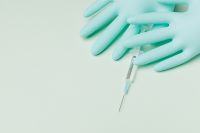 Kaboompics - Syringe Partly Hidden Beneath Blue Nitrile Gloves