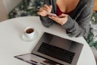 Kaboompics - A brunette woman works with a laptop and a phone