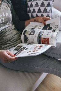 Kaboompics - Woman reading a designer magazine on a couch