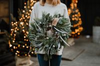 Kaboompics - Woman Holding Frosted Evergreen Wreath in Warm Christmas Lights