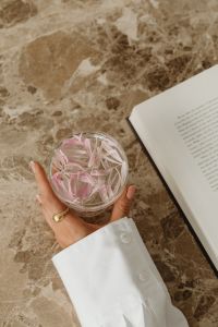 Kaboompics - Overhead Glass with Pink Petals, Open Book and Marble Copy Space