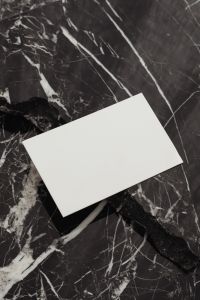 Kaboompics - Two Blank White Business Cards Stacked Vertically on Black Marble, Portrait Mockup